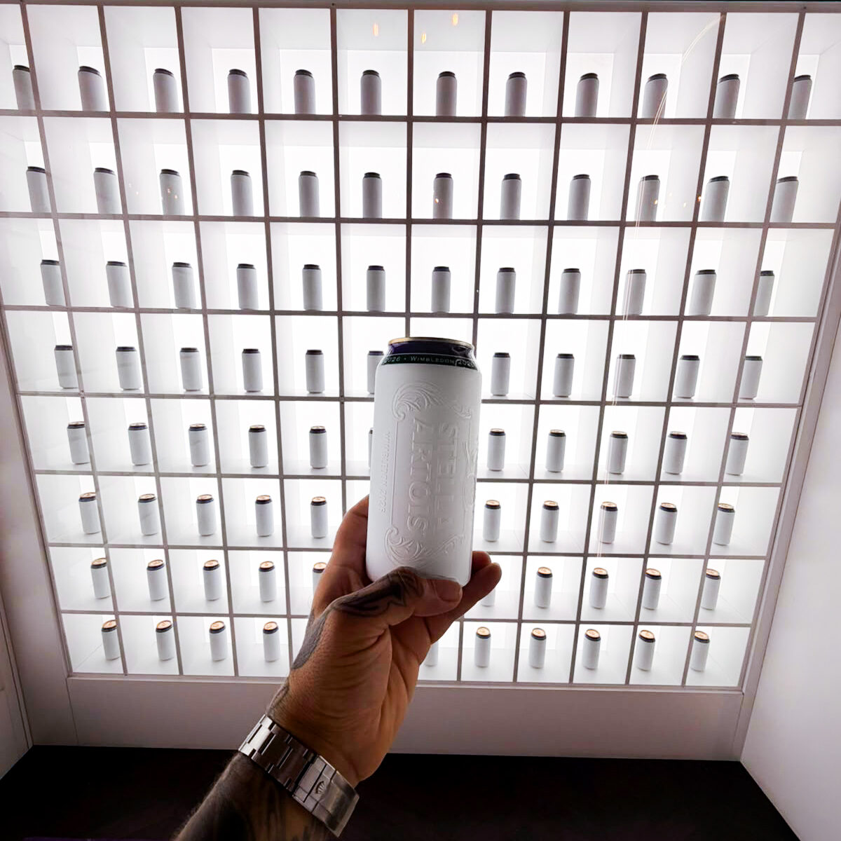 A finished can held in front of the display wall